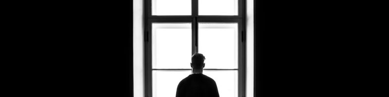 Man Looking Out Window